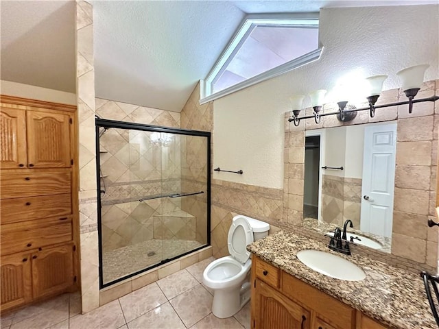 bathroom with tile patterned flooring, a shower with door, tile walls, and lofted ceiling