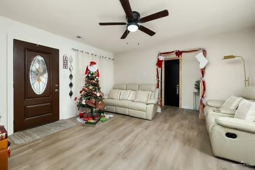 living room featuring ceiling fan and light wood-type flooring