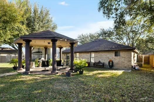 back of house with a gazebo, a patio area, and a lawn