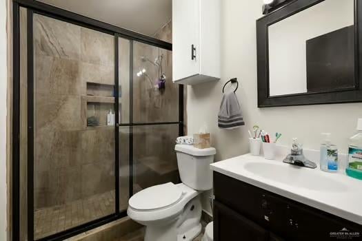 bathroom featuring vanity, an enclosed shower, and toilet