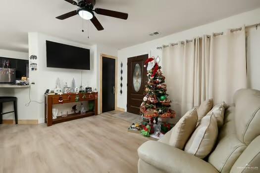 living room featuring hardwood / wood-style floors and ceiling fan