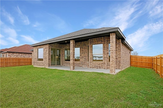 rear view of property with a patio and a lawn