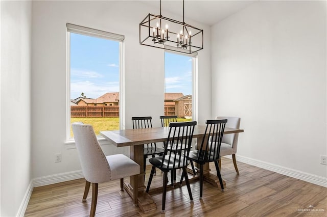 1405 Jocelyn Cir, Harlingen, TX 78552 - dining space featuring a wealth of natural light, baseboards, wood finished floors, and an inviting chandelier
