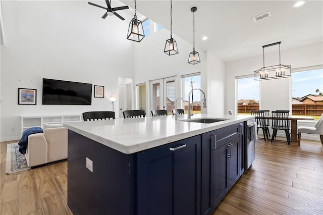 1405 Jocelyn Cir, Harlingen, TX 78552 - kitchen with wood finished floors, a kitchen island with sink, ceiling fan, a sink, and open floor plan