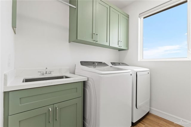 1405 Jocelyn Cir, Harlingen, TX 78552 - laundry room with light wood-style flooring, cabinet space, washing machine and clothes dryer, a sink, and baseboards