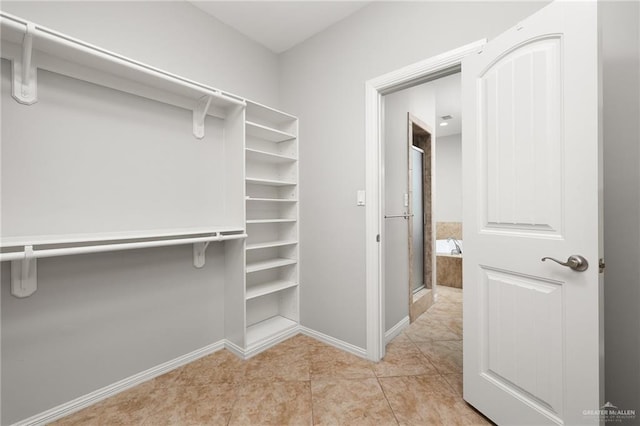 walk in closet with light tile patterned floors