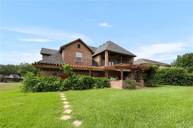 back of property featuring a yard and a pergola