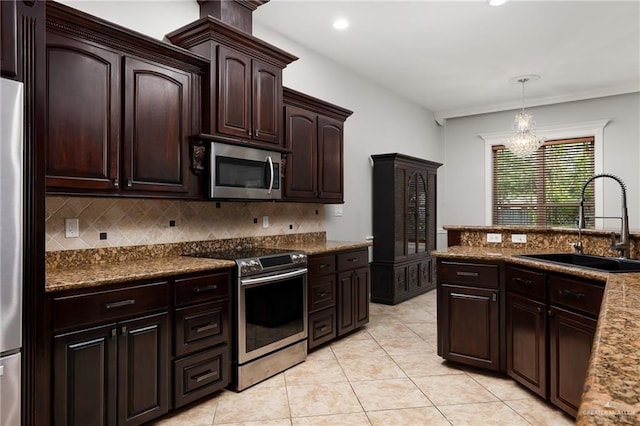 kitchen with pendant lighting, sink, appliances with stainless steel finishes, backsplash, and dark brown cabinetry