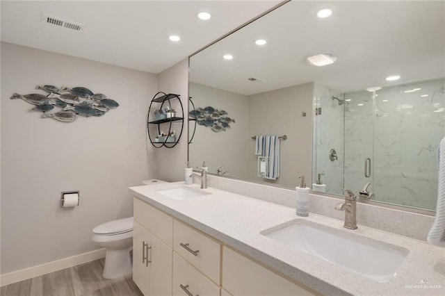 bathroom with hardwood / wood-style flooring, toilet, a shower with shower door, and vanity