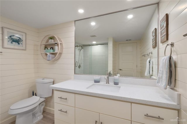 bathroom featuring vanity, toilet, wood-type flooring, and a shower with door