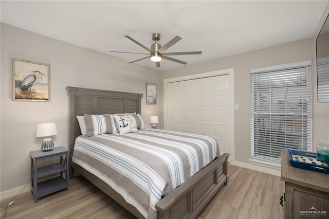 bedroom featuring ceiling fan, light hardwood / wood-style floors, and a closet