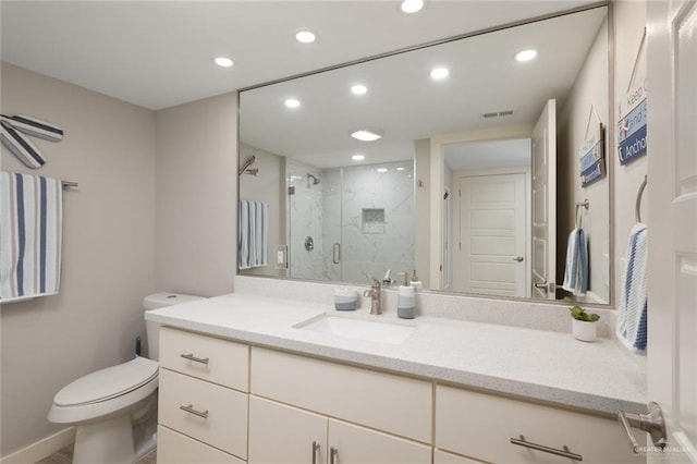 bathroom featuring toilet, vanity, and a shower with door