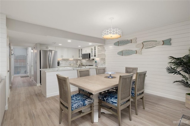 dining area with light hardwood / wood-style flooring and sink