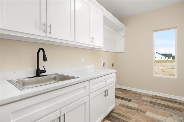 kitchen with light wood-style flooring, light countertops, white cabinetry, open shelves, and a sink