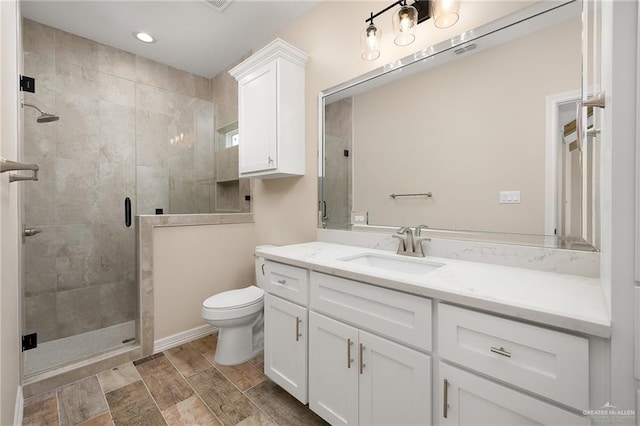 bathroom with visible vents, a stall shower, vanity, and toilet