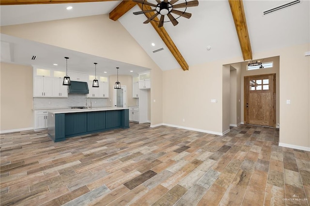 kitchen with light wood-style flooring, white cabinets, visible vents, and extractor fan