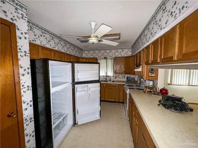 kitchen with electric range oven, sink, and ceiling fan