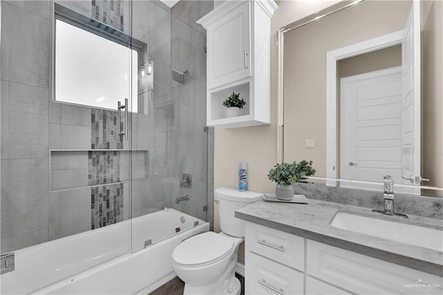 bathroom with toilet, bath / shower combo with glass door, and vanity