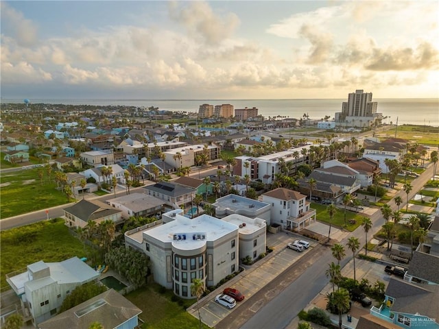 aerial view at dusk featuring a water view