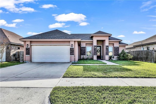 prairie-style house featuring a front lawn, fence, stucco siding, driveway, and an attached garage