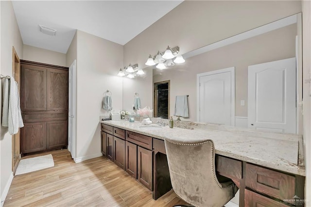 full bathroom featuring vanity, wood finished floors, visible vents, and baseboards