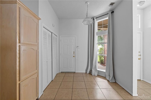 2706 E 28th St, Mission, TX 78574 - foyer with light tile patterned flooring, baseboards, and a textured ceiling