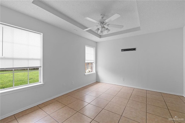 2706 E 28th St, Mission, TX 78574 - empty room featuring a raised ceiling, healthy amount of natural light, a textured ceiling, ceiling fan, and light tile patterned floors