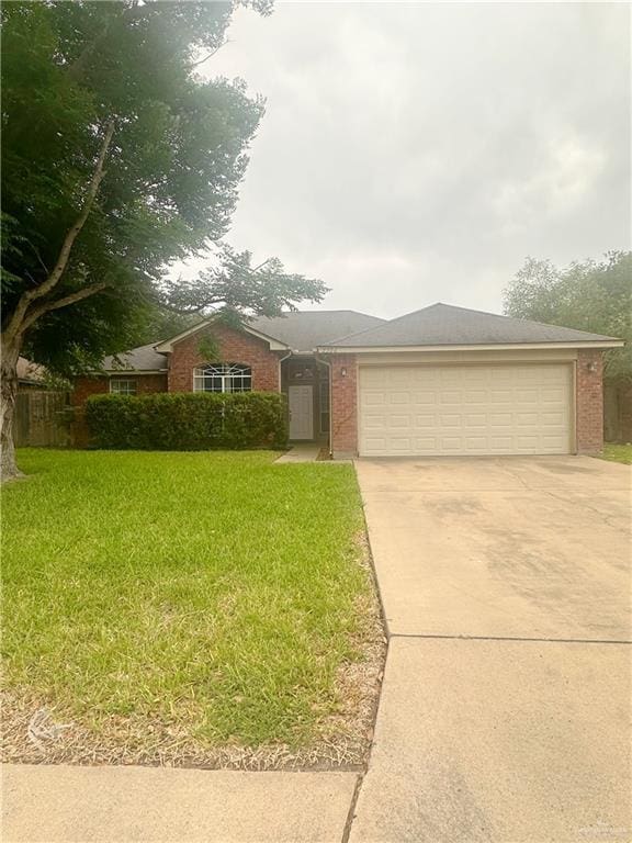 single story home featuring an attached garage, driveway, a front lawn, and brick siding