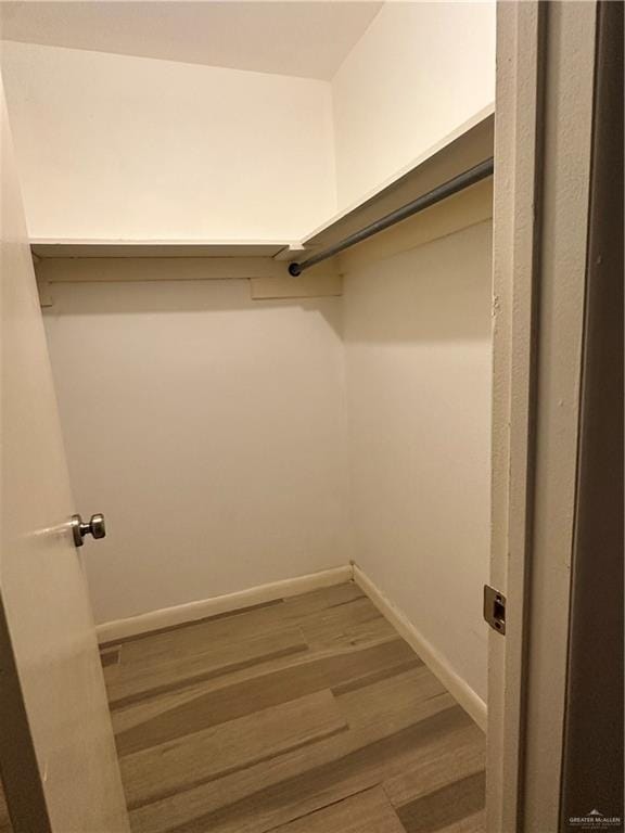 walk in closet with hardwood / wood-style floors