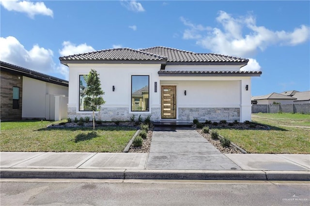 view of front of house featuring stone siding, a front lawn, and stucco siding