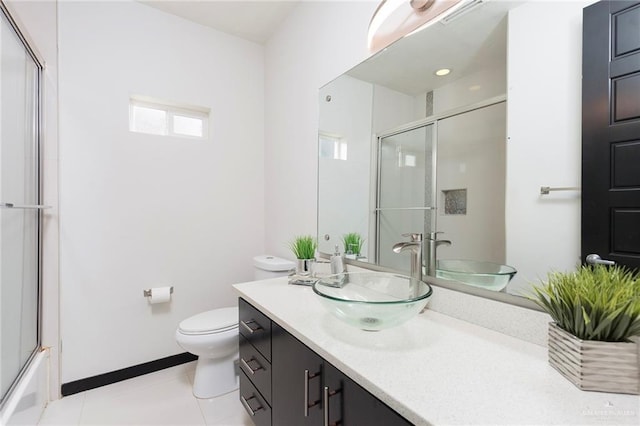 full bathroom with vanity, bath / shower combo with glass door, tile patterned floors, and toilet