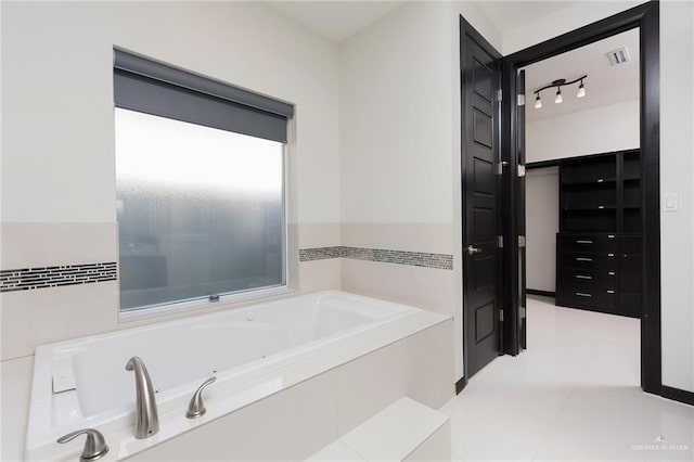 bathroom with tile patterned floors and tiled tub