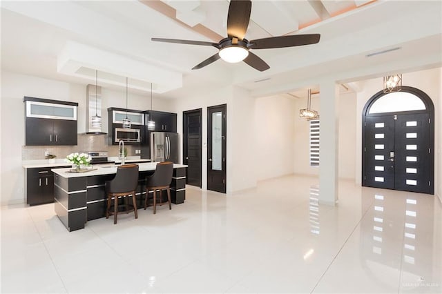 dining room featuring light tile patterned flooring, sink, ceiling fan, and a tray ceiling