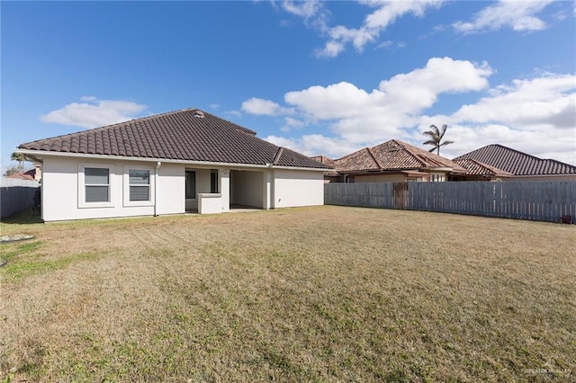 rear view of property featuring a lawn