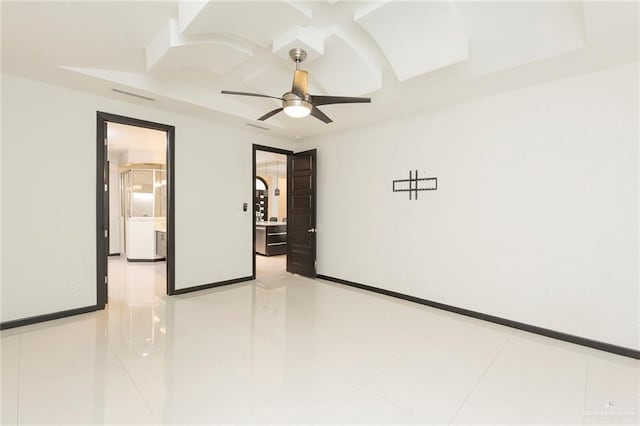 tiled spare room featuring ceiling fan and coffered ceiling