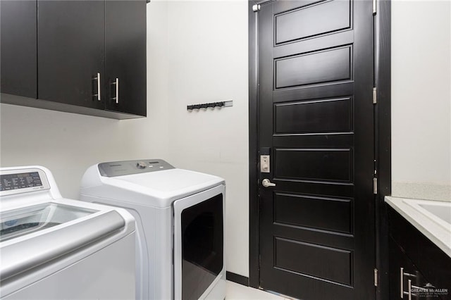 laundry room with washing machine and dryer and cabinets