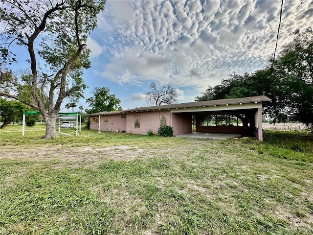 exterior space featuring a carport and a yard