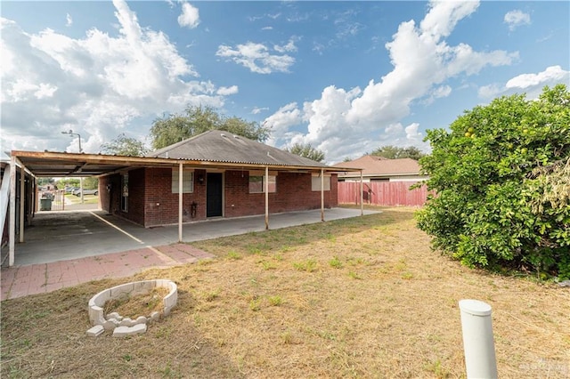 back of property with a yard and a carport