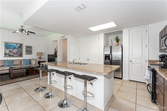 5909 Padre Blvd Unit 201, South Padre Island, TX 78597 - kitchen with stainless steel fridge with ice dispenser, range with electric cooktop, a sink, a breakfast bar area, and light stone countertops