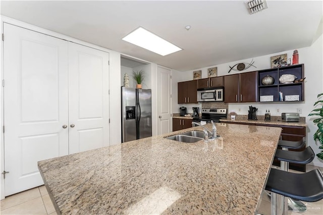 5909 Padre Blvd Unit 201, South Padre Island, TX 78597 - kitchen with appliances with stainless steel finishes, a sink, open shelves, dark brown cabinetry, and a breakfast bar area