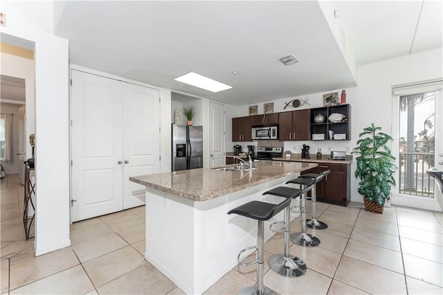 5909 Padre Blvd Unit 201, South Padre Island, TX 78597 - kitchen featuring stainless steel appliances, open shelves, a sink, dark brown cabinetry, and healthy amount of natural light