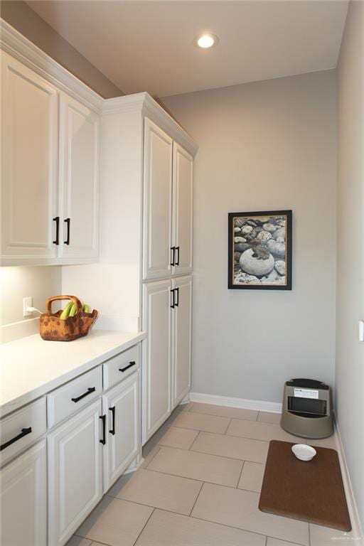 interior space featuring white cabinetry and light tile patterned flooring