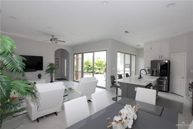 tiled living room featuring ceiling fan and sink