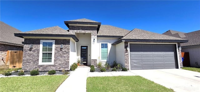 prairie-style home featuring a garage, driveway, a shingled roof, stone siding, and stucco siding