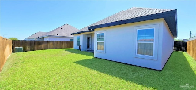 back of property with a yard, a fenced backyard, and stucco siding