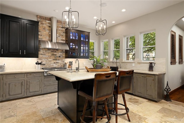 1509 Duke Ave, Mcallen, TX 78504 - kitchen featuring wall chimney range hood, a chandelier, light countertops, a breakfast bar area, and recessed lighting