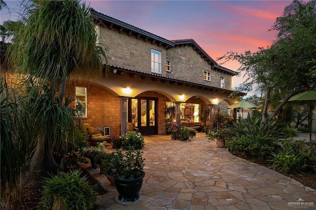 1509 Duke Ave, Mcallen, TX 78504 - back of house at dusk with french doors, a patio, and a tiled roof