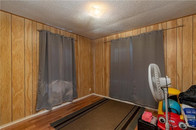 903 E San Antonio Ave, Pharr, TX 78577 - exercise area featuring a textured ceiling, wood finished floors, and wooden walls