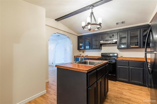 1815 N Jackson Rd, Edinburg, TX 78539 - kitchen with butcher block counters, black appliances, under cabinet range hood, and arched walkways