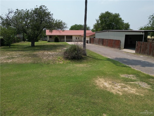 1815 N Jackson Rd, Edinburg, TX 78539 - ranch-style home featuring asphalt driveway, an outbuilding, and a front lawn